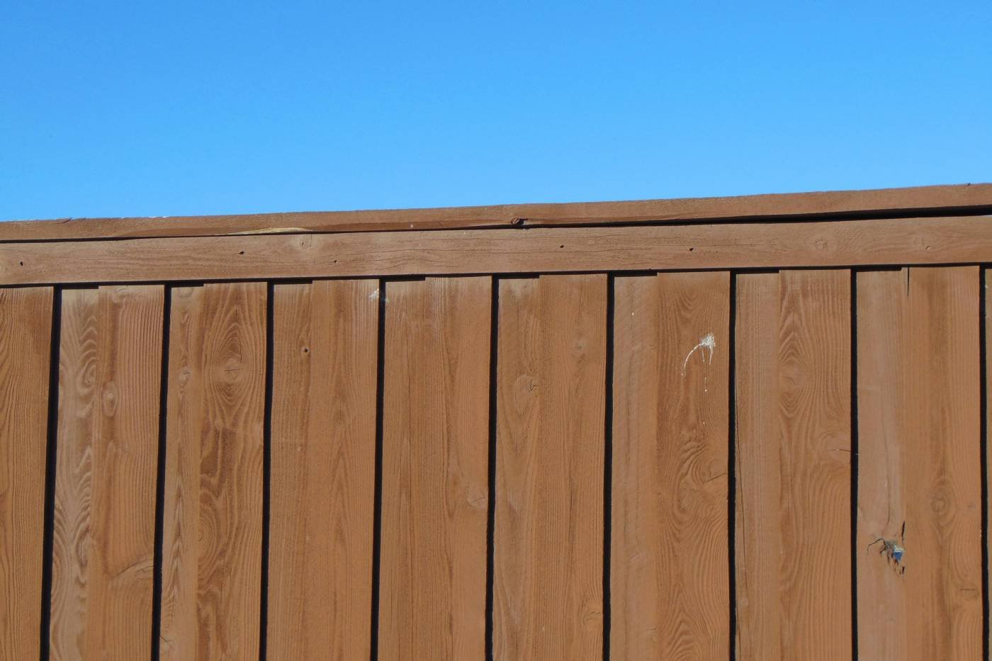 A timber fence against a blue sky