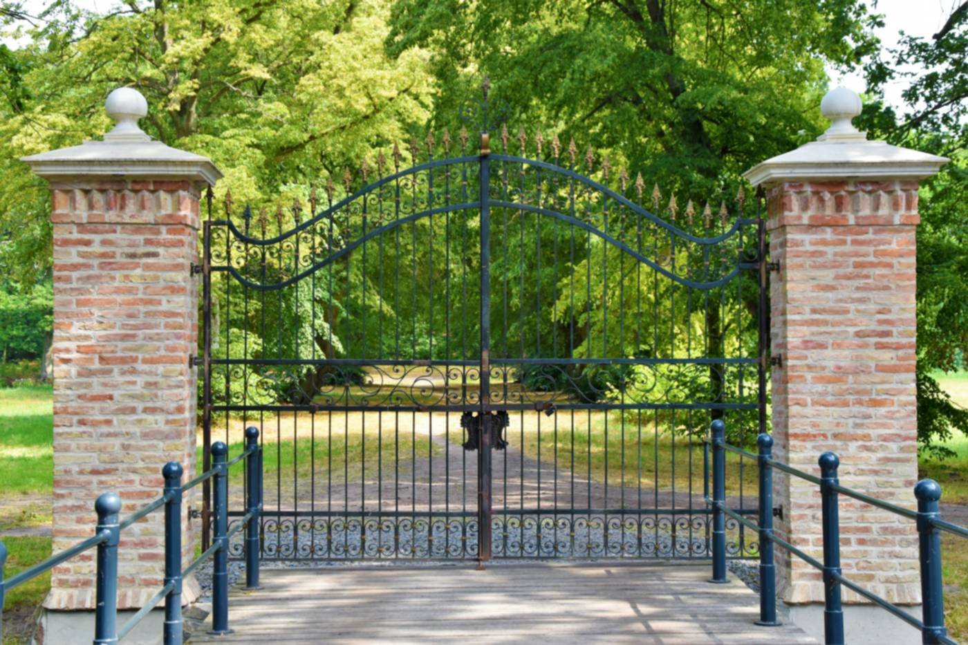 Metal driveway gates between brick piers